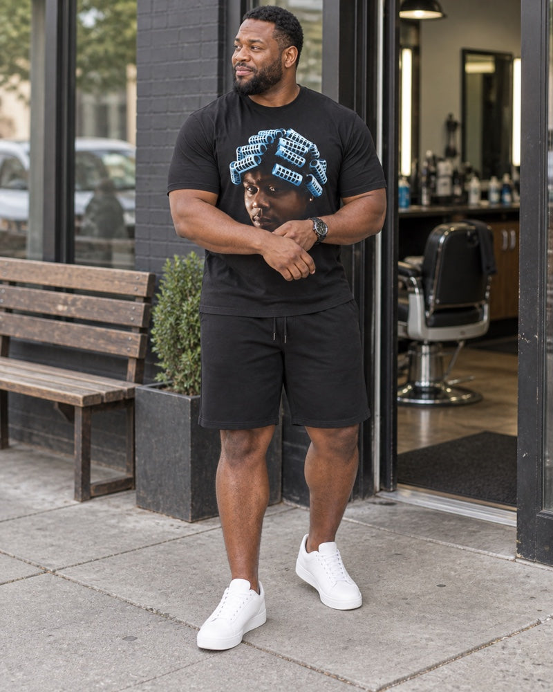 Big Worm Jumbo Graphic black T-shirt and shorts worn outside a neighborhood barbershop