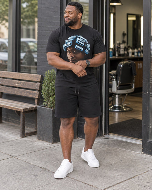 Big Worm Jumbo Graphic black T-shirt and shorts worn outside a neighborhood barbershop