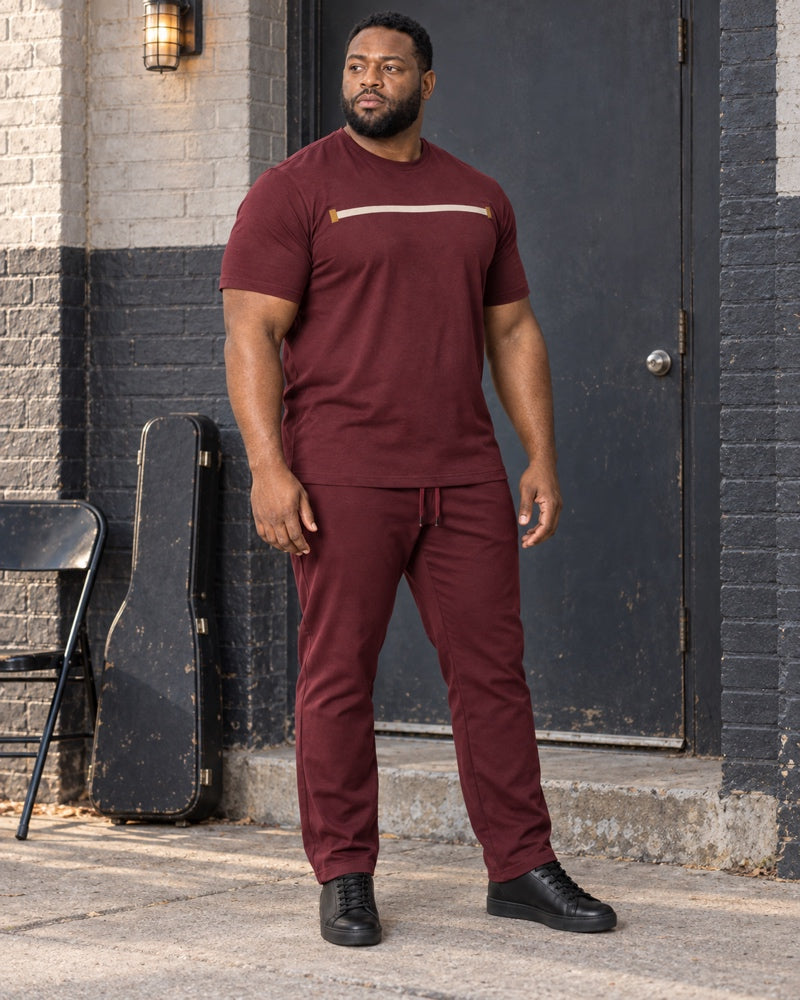 Burgundy Brass Quiet Span outfit worn at an ordinary neighborhood music-rehearsal building entrance with painted brick, folding chair, utility light and plain instrument case
