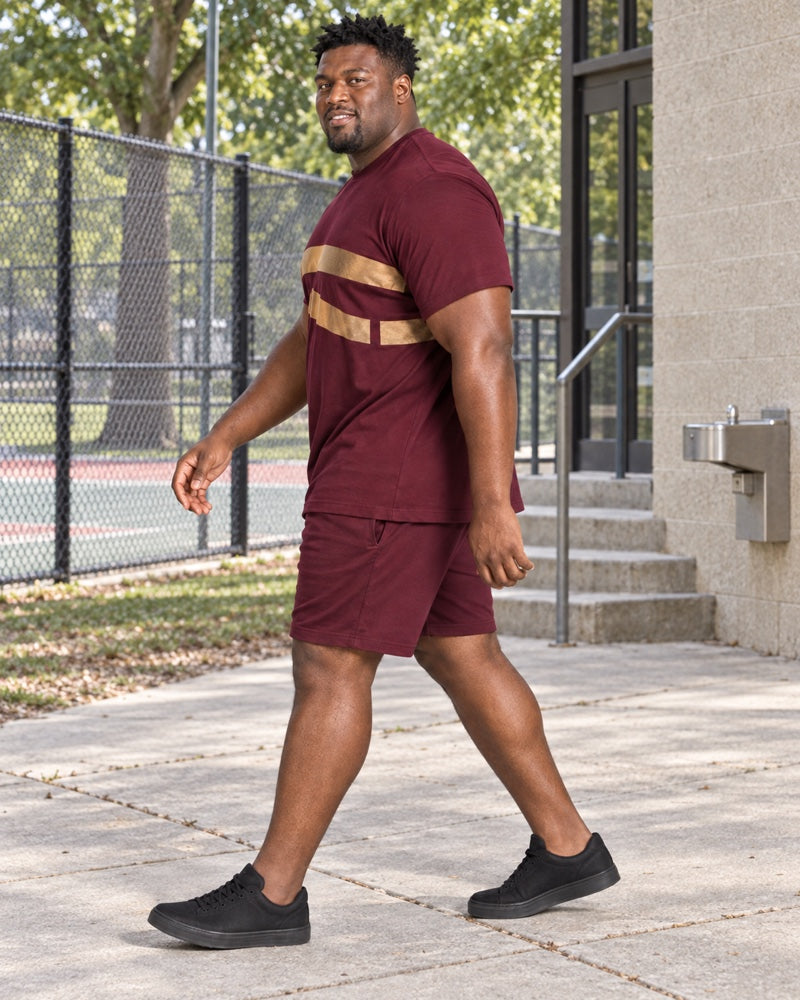 Burgundy Brass Wide Orbit outfit worn at an ordinary community recreation-center walkway with painted court fence, concrete steps, drinking fountain and shade trees