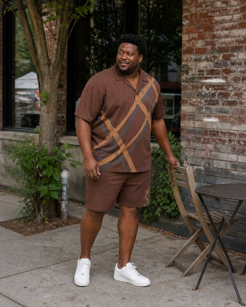 Big and tall man styling the Cedar Cane Shadow pocket-free camp shirt and matching shorts set outside a neighborhood cafe
