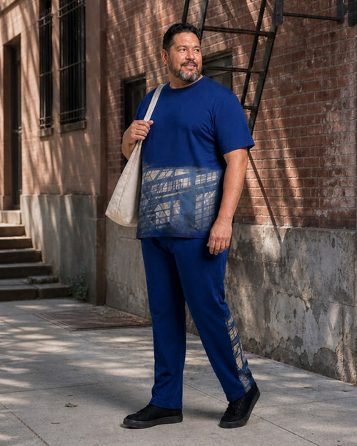 Big and tall man styling the Cobalt Fire Escape Shadow t-shirt and matching pants set in a lifestyle scene
