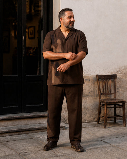 Big and tall man styling the Cocoa Keyhole Shadow pocket-free shirt and matching pants set in a lifestyle scene