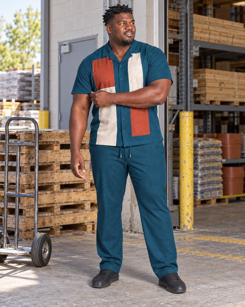 Deep Teal Rust Switchyard Blocks outfit worn at an ordinary neighborhood hardware loading bay with wood pallets, a plain hand truck, steel shelving and standard service door