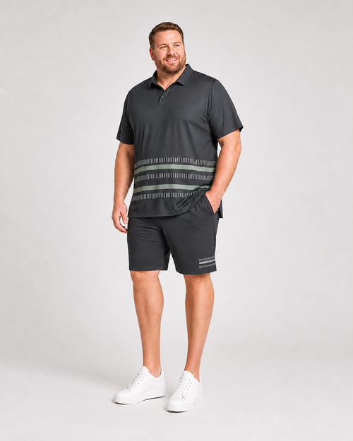 Big and tall man wearing the Jade Interval charcoal polo and matching shorts set, front three-quarter view