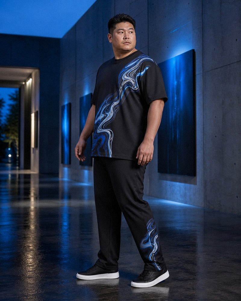 Big and tall man styling the Molten Lake Signal t-shirt and matching pants set in a natural lifestyle scene