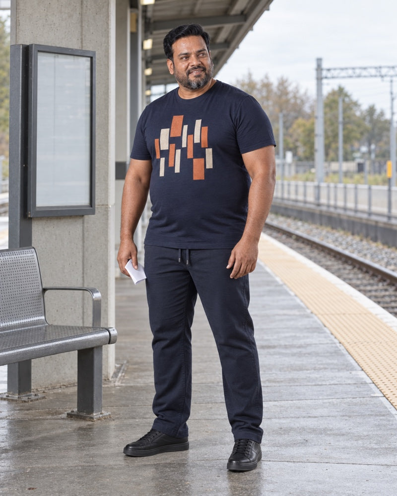 Navy Rust Deco Relay outfit worn at an ordinary commuter rail platform with concrete columns, metal bench, blank timetable case and textured paving