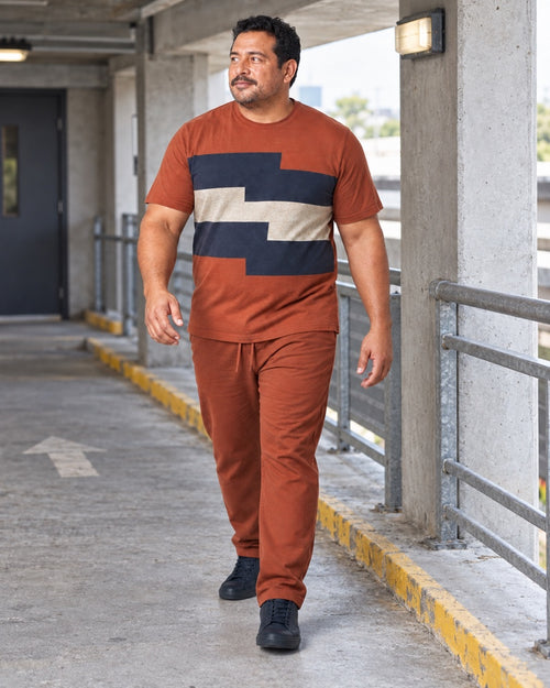 Rust Navy Terrace Shift outfit worn at an ordinary municipal parking-ramp walkway with concrete columns, a waist-high rail, painted curb and utility light